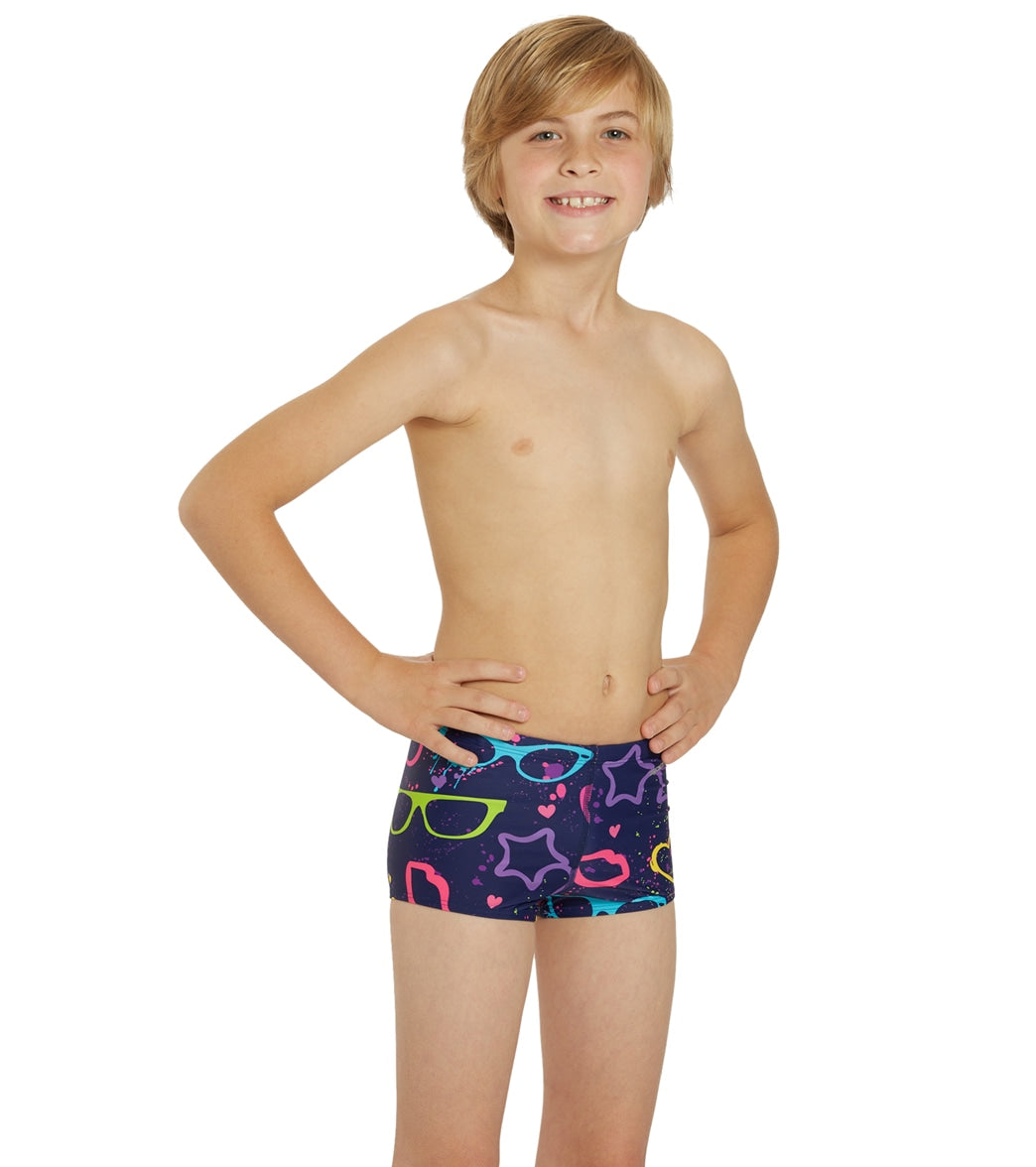 a young boy wearing a pair of colorful boys square leg swimsuit with a playful pattern featuring glasses, stars, and hearts